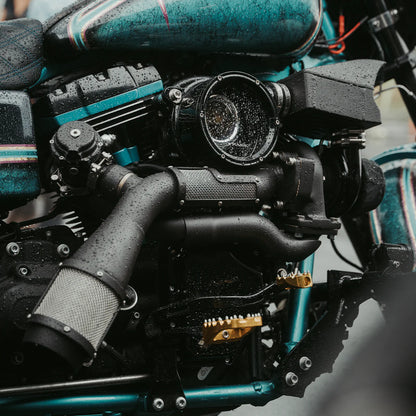 Close up photo of an orange Harley Davidson Dyna with the blacked out Trask Dyna assault turbo kit installed 