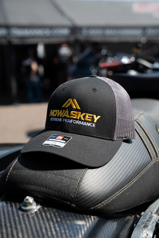 This black and gray Nowaskey hat combines a sleek black front with a breathable gray mesh back. Featuring a snapback closure and a subtle embroidered logo, it offers both style and comfort for any casual look.